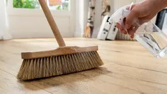 De bezem besproeien met een mengsel van azijn en water: waarom is het aan te raden om dit te doen voordat je gaat vegen en waarom is het nodig?